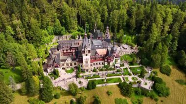 Romanya 'nın Prahova Eyaleti' ndeki Peles Kalesi 'nin güzel manzarası. Çevrede yemyeşil çam ağacı ağacı yetişiyor. Hava görünümü.