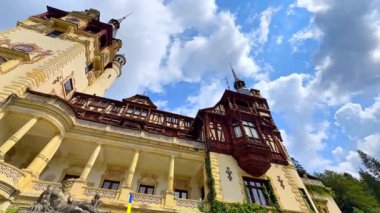 Güzel peruklu Neo-Rönesans Sarayı. Romanya 'nın Prahova İlçesi' ndeki Peles Şatosu 'nun alçak açılı manzarası bulutlu gökyüzünün arka planında.