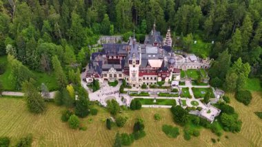 Romanya 'nın Prahova İlçesi' nde Sinaia yakınlarındaki Carpathian Dağları 'ndaki Sinaia Kraliyet Bölgesi' nde Neo-Rönesans Sarayı. Bölgeden bir sürü insan geçiyor. Hava görünümü.