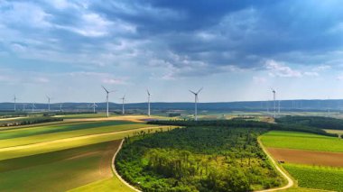 Rüzgar türbinleri olan yeşil tarım alanları. Yenilenebilir güç üretimi. Hava görünümü.