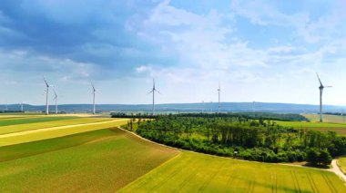 Rüzgar türbinleriyle tarımsal plantasyonların üzerindeki görüntüler. Yeşil enerji üretimi.