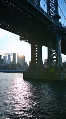 Manhattan Köprüsü 'nün altından gidiyorum. New York 'ta East River' da bir nehir gezisi. Dikey video.