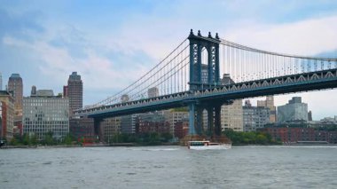 Tekneler Doğu Nehri 'nden Manhattan Köprüsü' ne doğru hareket ediyor. Düşük açı. New York, ABD 'de tekne gezisi.