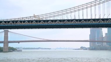 Manhattan Köprüsü 'nden geçen uzun tren. Sisli bir günde nehir manzarasından köprünün alçak açılı görüntüsü.