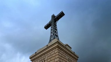 Caraiman Cross monument against cloudy sky. Monumental metal Caraiman Cross rising against dramatic sky in the Bucegi Mountains.