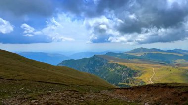 Panoramic plateau view from Bucegi Mountains. Wide plateau with trails and ridges under cloudy sky in the Bucegi Mountains.