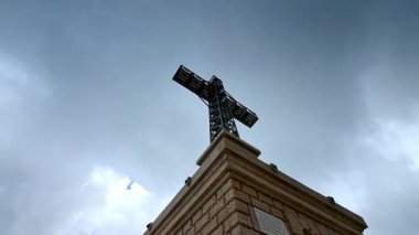 Close view of Caraiman Cross monument in Bucegi Mountains. Low angle view of the iconic Caraiman Cross structure under cloudy sky.