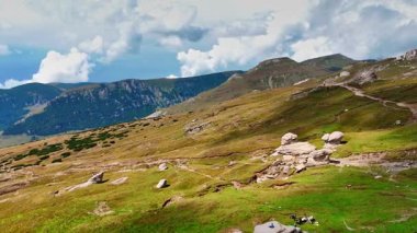 Bucegi Plateau rocks and green slopes. Panoramic view of Bucegi Plateau with eroded rocks and green hills.