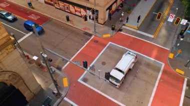 View on the crossroad paved by the red bricks in the street of a modern city. Looking up at the high-rise building on the corner of the street. Pittsburg, Pennsylvania, USA.