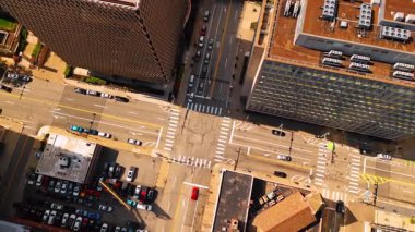 Crossroad among the high-rise buildings in the city. Top view. Lots of cars stand at the parking lot. Pittsburgh, Pennsylvania, USA.