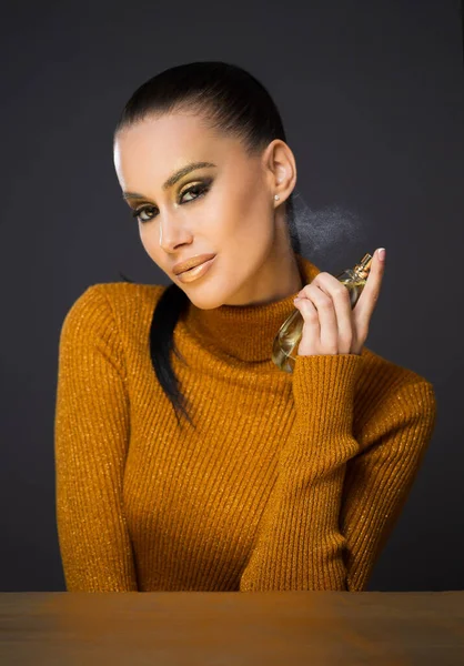 Piękne Młody Brunetka Model Pozowanie Złoty Luksusowy Makijaż Pomocą Perfum — Zdjęcie stockowe