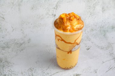 Mango Graham Shake adında yeni yapılmış soğuk bir içecek fotoğrafı, çeşitli malzemelerle..