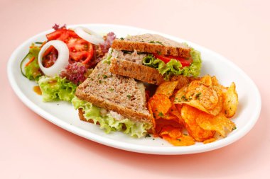 Photo of freshly made chicken spread sandwich served with chips and salad. clipart