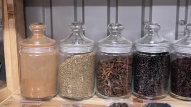 Marketteki bir rafta renkli baharat. Badian, zencefil, curcumin, caraway, biber ve diğer baharatlar raflarda.