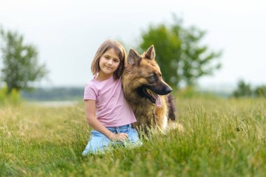 Yaz parkında çoban köpeğine sarılan küçük kız. Yüksek kalite fotoğraf