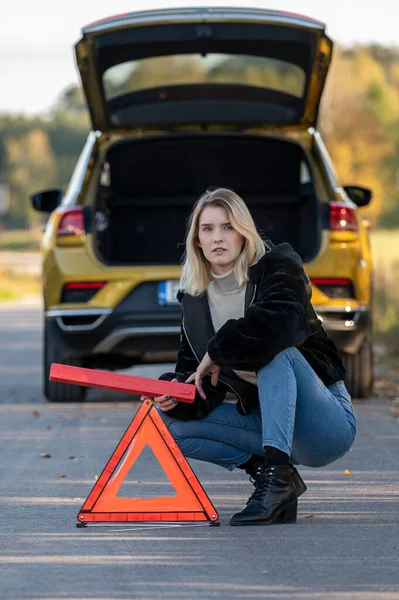 stock image A woman waiting for roadside assistance.