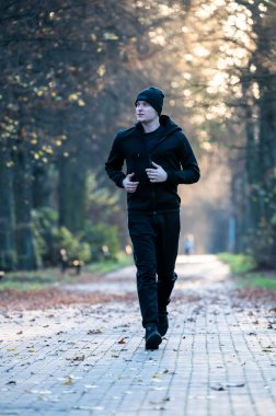 Sonbahar parkında koşucu.