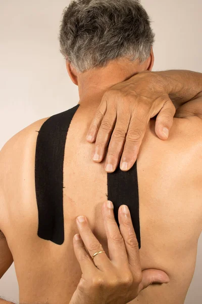 Volwassen Man Met Kinesio Tape Zijn Rug Voor Pijnbestrijding — Stockfoto
