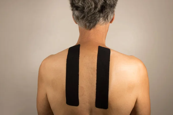 stock image Mature Man with Kinesio Tape on his back for pain management