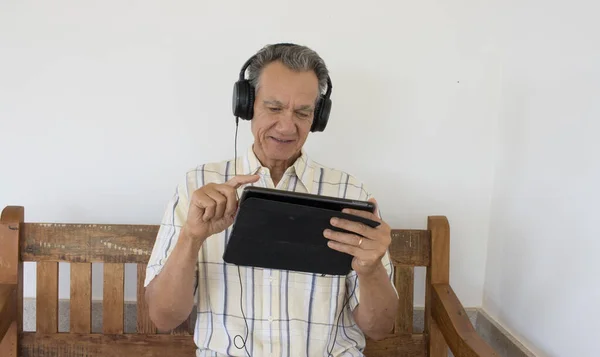 Dışarıda Oturan Olgun Bir Adam Ipad Smart Tabletinde Kulaklık Takmış — Stok fotoğraf