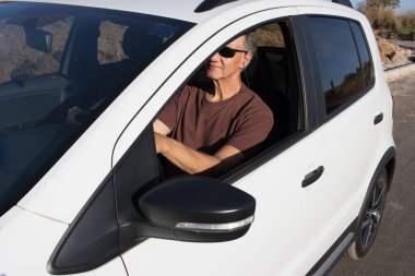 Olgun Adam arabasıyla şehir dışına geziye çıkıyor.