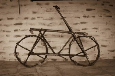 Ev yapımı ahşap bir bisiklet tuğla bir duvara dayanıyor. 