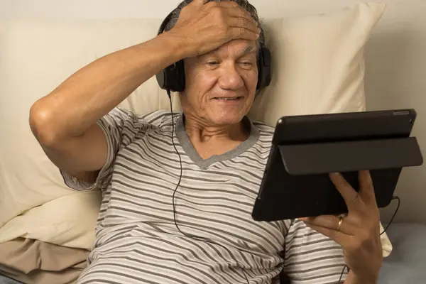 Mature Man Wearing Headphones Lying Bed Watching Movie His Ipad — Stock Photo, Image
