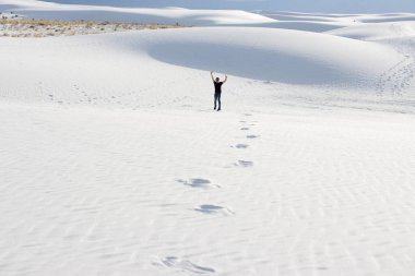 Genç adam New Mexico 'daki White Sands Ulusal Parkı' nda havada zıplıyor.