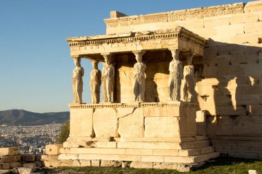 Erechtheion ve Partenon 'daki Caryatids' in sundurması Akropolis 'in antik harabelerinin tepesinde.