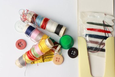 İplik Şırıngaları, Yüksük ve Düğmeler ile beyaz zemin üzerinde Farklı Renk Spikerleri ile Seyahat Seti