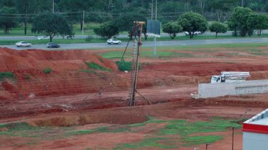 Brasilia, DF Brezilya 25 Nisan 2025 Brasilia 'nın kuzeybatı kesiminde yeni bir yol yapımında Yığın Sürücüsü kullanılıyor