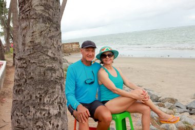 Plajda plastik sandalyelerde oturan çift Maceio Alagoas Brezilya 'da Punta Verde olarak biliniyor.