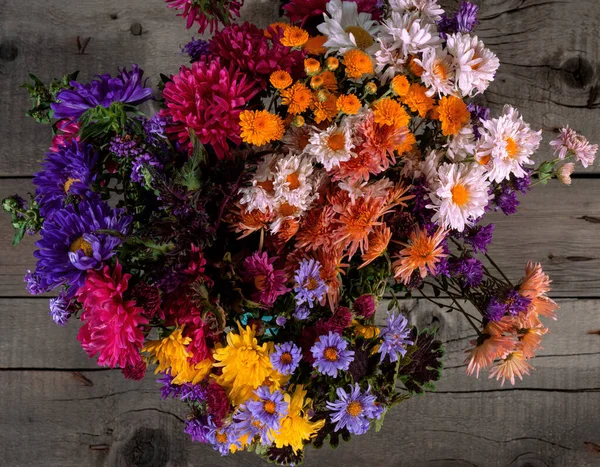 Wild Colorful Rustic Flowers Bouquet from Daisy, Chrysanthemum and Others. Wooden Rustic Table on Background Is in Blurred Focus. Mothers Day, Summer and Spring Holiday Wallpaper.