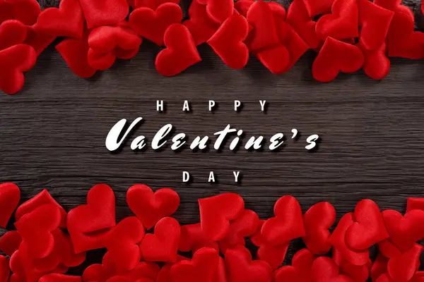 Ahşap arka planda kırmızı kalplerle Sevgililer Günü karşılaması romantik bir tema yaratır..