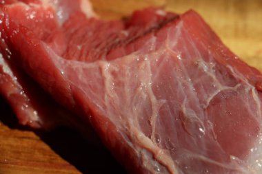 Ahşap bir mutfak doğrama tahtasının üzerinde kesilmiş kırmızı et parçası. Yüksek kalite fotoğraf