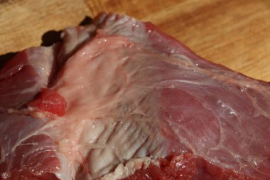 Ahşap bir mutfak doğrama tahtasının üzerinde kesilmiş kırmızı et parçası. Yüksek kalite fotoğraf