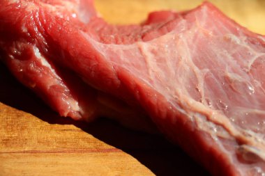 Ahşap bir mutfak doğrama tahtasının üzerinde kesilmiş kırmızı et parçası. Yüksek kalite fotoğraf