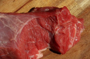 Ahşap bir mutfak doğrama tahtasının üzerinde kesilmiş kırmızı et parçası. Yüksek kalite fotoğraf