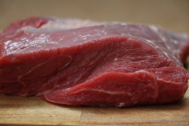 Ahşap bir mutfak doğrama tahtasının üzerinde kesilmiş kırmızı et parçası. Yüksek kalite fotoğraf
