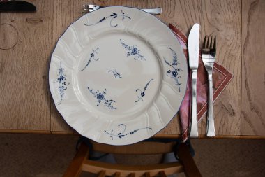 Alman tarzı tabak, ahşap masa üzerinde mavi süsler ve çatal bıçak takımı. Yüksek kalite fotoğraf