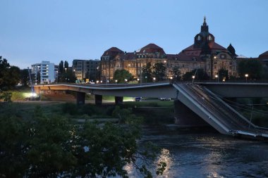 DRESDEN, GERMANY - 11 Eylül 2024: Bruehls Terasse veya Bruehlsche Terasse 'den alacakaranlıkta kısmen çökmüş Carola köprüsü. Yüksek kalite fotoğraf