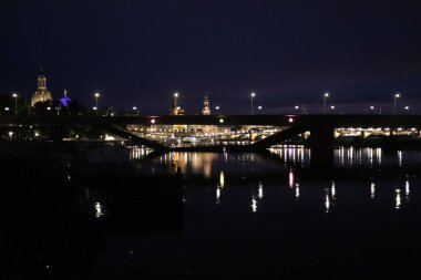 DRESDEN, GERMANY - 11 Eylül 2024: arka planda Dresden silueti olan gece yarısı kısmen çökmüş Carola köprüsü. Yüksek kalite fotoğraf