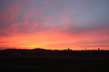 HAAG in OBERBAYERN, ALMANY - 18 Nisan 2025: Oberbayern 'deki Skyline of Haag günbatımında canlı renkler ve sakin manzaralar sergiliyordu. Yüksek kalite fotoğraf