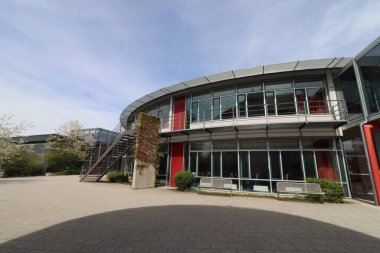HAAG, GERMANY - 20 Nisan 2025: Oberbayern 'de yeni inşa edilen Realschule Haag büyük cam pencereli ve kırmızı mimari aksanlı kavisli modern bir tasarıma sahiptir. Yüksek kalite fotoğraf