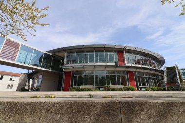 HAAG, GERMANY - 20 Nisan 2025: Oberbayern 'deki Realschule Haag' ın iki binasını birbirine bağlayan cam kaplı yaya köprüsü, kırmızı yapısal unsurlar tarafından desteklenmektedir. Yüksek kalite fotoğraf