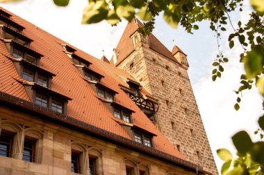 NUREMBERG, GERMANY - 27 Temmuz 2013: Nuremberg Şatosu 'nun ayırt edici taş kulesi ve kırmızı çatılı mimarisi, ortaçağ mirasının bir sembolü. Yüksek kalite fotoğraf
