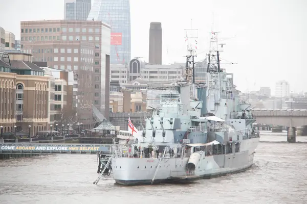 Londra, İngiltere - 30 Aralık 2017: Belfast Thames Nehri 'ne demirlemiş ve bulutlu bir günde arka planda şehrin silueti vardı. Yüksek kalite fotoğraf