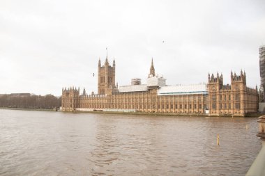 LONDRA, BİRLİK KINGDOM - 30 Aralık 2017: Bulutlu bir günde Parlamento Binaları ve Thames Nehri boyunca Büyük Ben. Yüksek kalite fotoğraf