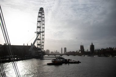 BİRLİK KINGDOM - 30 ARALIK 2017: Teknelerle ve gün batımında ikonik gökyüzü ile Londra Gözü ve Thames Nehri 'nin silueti. Yüksek kalite fotoğraf