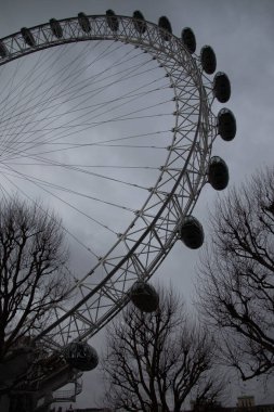 LONDRA, BİRLİK KINGDOM - 30 ARALIK 2017: Siluetli çıplak ağaç dalları ve bulutlu bir kış gökyüzü ile Londra Gözü 'nün yukarıdan görünüşü. Yüksek kalite fotoğraf